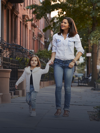 Mother and daughter walking by apartments